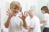 Students+in+bathroom+at+sinks+washing+hands+with+one+holding+up+soapy+hands+%28selective+focus%29