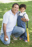 Grandfather+and+grandson+holding+baseball+bat+and+smiling