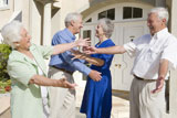 Two+senior+couples+greeting+each+other+with+open+arms