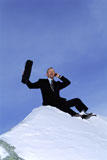 Businessman+outdoors+on+snowy+mountain+using+cellular+phone+and+yelling