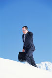 Businessman+outdoors+on+snowy+mountain+using+cellular+phone