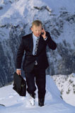 Businessman+outdoors+on+snowy+mountain+using+cellular+phone