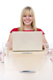 Businesswoman+sitting+in+boardroom+with+laptop+smiling