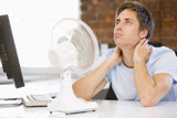Businessman+in+office+with+computer+and+fan+cooling+off