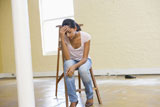 Woman+sitting+on+ladder+in+empty+space+looking+tired