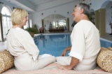Middle+Aged+Couple+Relaxing+By+Swimming+Pool