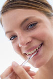Woman+with+lipgloss+applicator+smiling