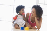 Mother+and+daughter+indoors+playing+and+smiling
