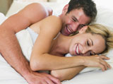 Couple+lying+in+bed+laughing