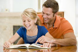 Man+and+young+girl+reading+book+in+dining+room+smiling