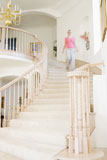 Woman+coming+down+staircase+in+luxurious+home