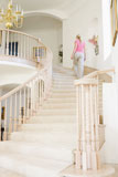 Woman+going+up+staircase+in+luxurious+home