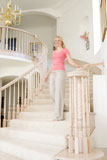 Woman+coming+down+staircase+in+luxurious+home