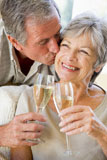 Couple+in+living+room+toasting+champagne+kissing+and+smiling