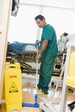 An+Orderly+Mopping+The+Floor+In+A+Hospital+Ward