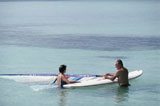 High+angle+view+of+a+mid+adult+couple+holding+a+windsurfing+board+in+water
