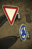 Close-up+of+a+yield+sign+and+a+traffic+circle+on+the+wall