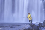 Mid+adult+man+fly-fishing+near+a+waterfall
