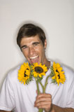 Portrait+of+a+young+man+holding+sunflowers+and+laughing