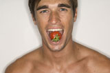 Portrait+of+a+young+man+holding+a+strawberry+in+his+mouth