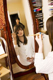 Reflection+of+a+teenage+girl+applying+make-up+to+her+face+with+her+mother+standing+behind+her