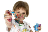 Child+with+blue+paint+bottle+and+brush.+Covered+in+paint.+Clipping+path.