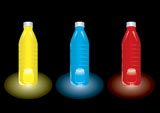 Three+bottles+of+different+coloured+juice+set+against+a+black+background