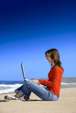 Woman+working+with+a+laptop+on+the+beach