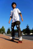 Boy+on+a+Skateboard+Against+Blue+Sky+Looking+in+the+Sun+