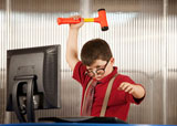 Nerdy+young+boy+smashing+his+computer+with+a+hammer+