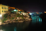 Mostar+old+town+at+night+with+the+Luka+Bridge+above+the+Neretva+river.+