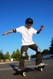 Teenage+boy+having+fun+skateboarding+on+a+parking+lot+on+a+sunny+day.+