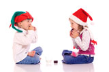 Cute+little+children+with+christmas+hats+eating+cookies+and+laughing+