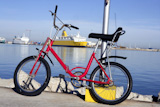 bicycle+parked+in+a+harbour+over+blue+water%2C+yellow+boat%2C+red+bike