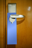 Hotel+door+handle+with+a+copy+space+blue+paper+note%2C+do+not+disturb