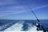 Fishing+rod+and+reel+on+a+boat%2C+vacation+on+blue+sea+and+summer+sky