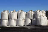 salt+big+bags+sacks+stacked+rows+for+iced+roads+blue+sky