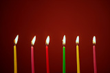 Colorful+birthday+light+candles+in+a+row+red+background