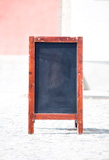 Blackboard+with+wooden+frame+on+city+street.