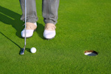 Golf+green+hole+course+man+putting+ball+inside+short+putt