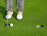 Golf+green+hole+course+man+putting+ball+inside+short+putt