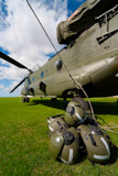 A+Boeing+CH-47+Chinook+with+the+rotor+blades+all+tied+down+and+the+crew%27s+helmets+in+the+foreground