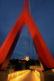 Walking+Along+A+Bridge+Through+A+Red+Triangular+Arch+In+France