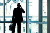 Businessman+silhouetted+in+large+office+window.