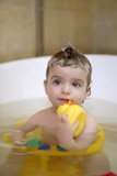 baby+little+girl+on+bath+playing+yellow+duck+inside+water