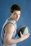 basketball+young+man+basket+player+portrait+over+blue+studio+background