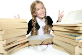 little+student+blond+braided+girl+smiling+with+lots+of+stacked+books+on+white+background