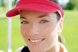 sport+woman+closeup+portrait+face+similing+sun+visor+cap+tennis+golf