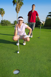 playing+golf+young+woman+looking+and+aiming+for+the+hole