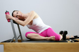 aerobic+gym+pilates+woman+rest+holding+water+bottle+in+reformer+bed